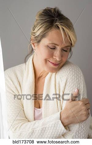 Stock Photo - Caucasian woman wrapped in warm sweater. Fotosearch