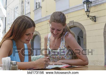 Caucasian women reading at sidewalk cafe View Large Photo Image Stock Photograph - Caucasian women reading at sidewalk cafe. Fotosearch
