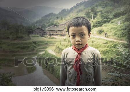 Stock Photograph - Chinese boy standing in rice paddy fields. Fotosearch
