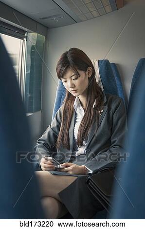 Chinese businesswoman using cell phone on airplane View Large Photo Image Stock Image - Chinese businesswoman using cell phone on airplane. Fotosearch