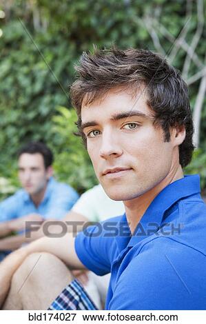 Stock Photo - Close up of serious man sitting in backyard. Fotosearch