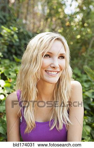 Close up of smiling woman sitting outdoors View Large Photo Image Stock Image - Close up of smiling woman sitting outdoors. Fotosearch