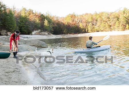 Stock Photo - Couple kayaking in remote lake. Fotosearch