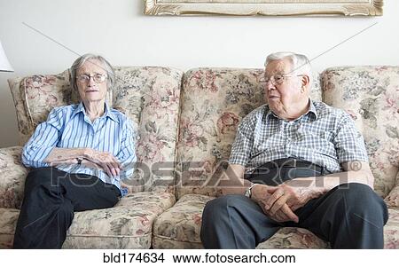 Picture - Couple sitting on sofa. Fotosearch