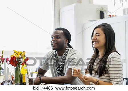 Couple smiling at dining room table View Large Photo Image Stock Photograph - Couple smiling at dining room table. Fotosearch