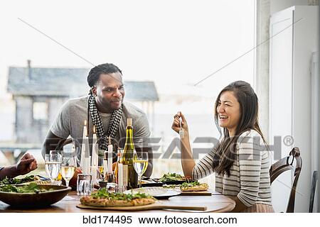 Stock Photography - Couple talking at dinner party. Fotosearch