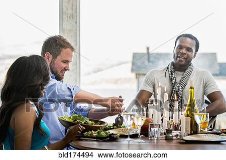 Picture - Friends eating at dinner party. Fotosearch