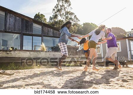 Friends playing in sand View Large Photo Image Stock Photo - Friends playing in sand. Fotosearch