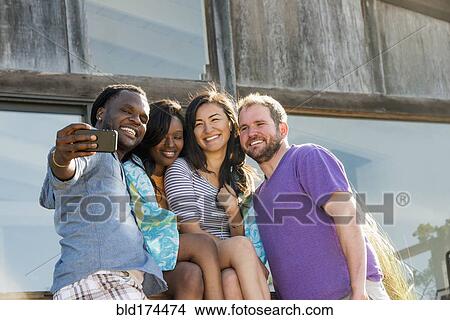 Picture - Friends taking selfie outdoors. Fotosearch