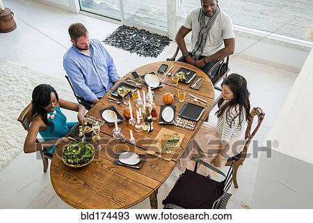 Stock Image - Friends talking at dinner party. Fotosearch