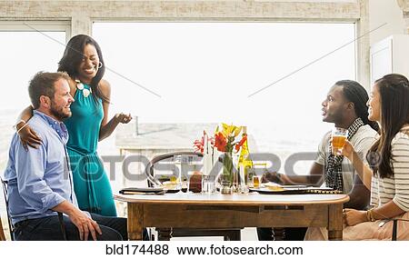 Friends talking at dinner party View Large Photo Image Stock Photo - Friends talking at dinner party. Fotosearch