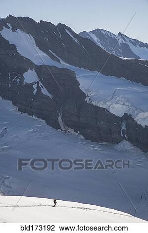 Hiker on snowy mountain slopes View Large Photo Image Stock Image - Hiker on snowy mountain slopes. Fotosearch