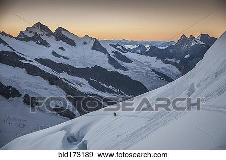 Hiker on snowy mountain slopes View Large Photo Image Stock Photo - Hiker on snowy mountain slopes. Fotosearch