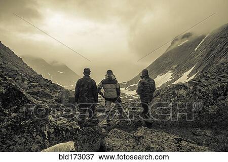 Hikers admiring mountain valley View Large Photo Image Stock Photo - Hikers admiring mountain valley. Fotosearch