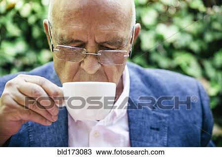 Stock Image - Hispanic businessman drinking cup of coffee. Fotosearch