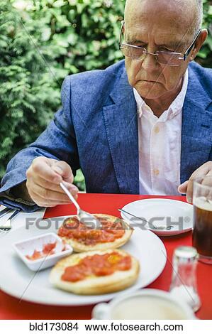 Hispanic businessman eating breakfast outdoors View Large Photo Image Picture - Hispanic businessman eating breakfast outdoors. Fotosearch