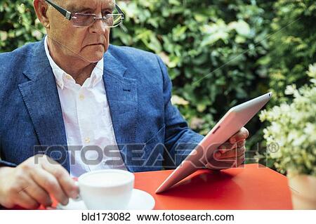 Stock Image - Hispanic businessman using digital tablet. Fotosearch