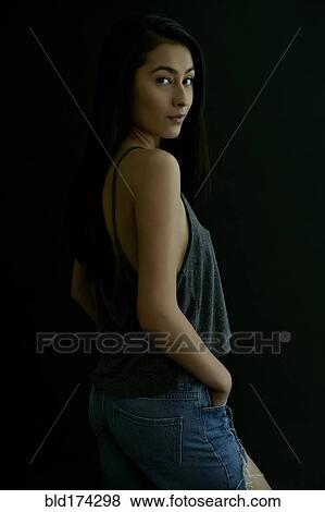 Stock Photo - Hispanic woman looking over shoulder. Fotosearch