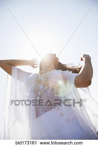 Hispanic woman standing under blue sky View Large Photo Image Stock Image - Hispanic woman standing under blue sky. Fotosearch