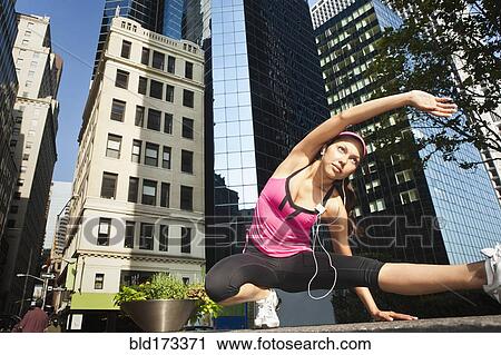 Hispanic woman stretching under highrise buildings View Large Photo Image Stock Image - Hispanic woman stretching under highrise buildings. Fotosearch