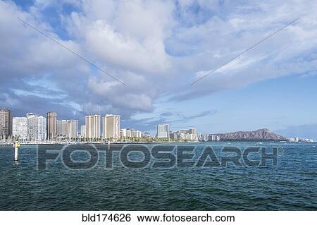 Stock Photograph - Honolulu city skyline over ocean, Hawaii, United States. Fotosearch
