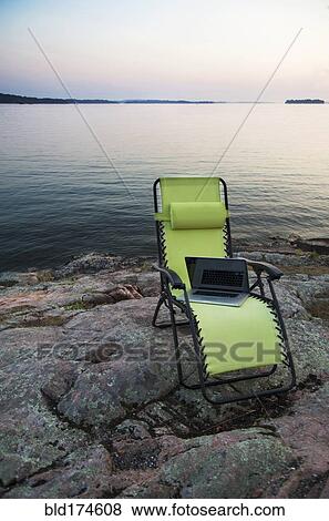 Laptop on lawn chair near remote river View Large Photo Image Stock Photo - Laptop on lawn chair near remote river. Fotosearch
