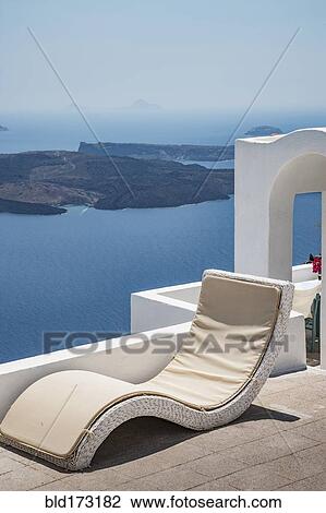 Stock Image - Lawn chair on hilltop overlooking ocean. Fotosearch