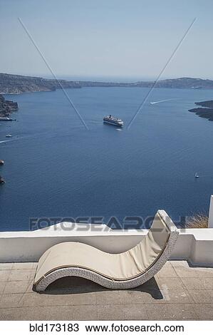 Stock Image - Lawn chair on hilltop overlooking ocean. Fotosearch