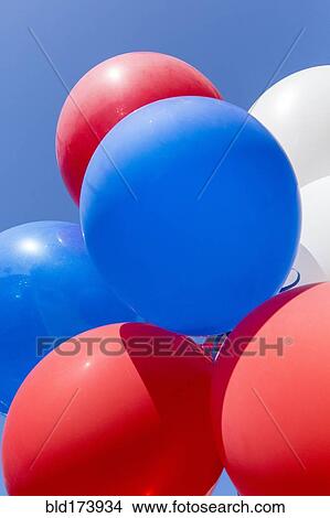 Low angle view of balloons under blue sky View Large Photo Image Picture - Low angle view of balloons under blue sky. Fotosearch