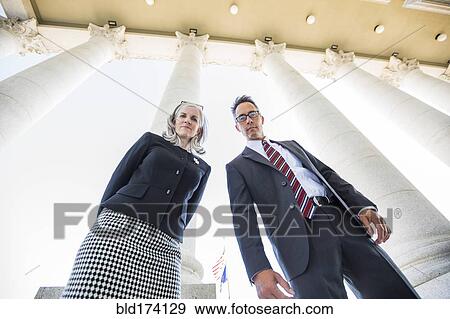 Low angle view of business people under columns View Large Photo Image Stock Photo - Low angle view of business people under columns. Fotosearch