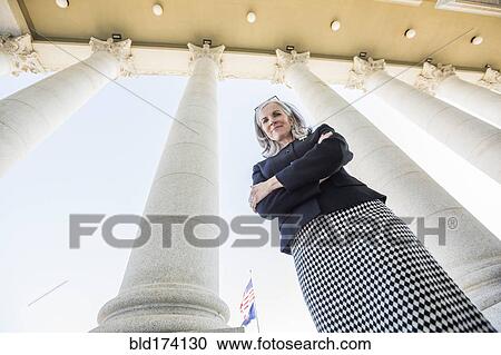 Low angle view of Caucasian businesswoman standing under columns View Large Photo Image Stock Image - Low angle view of Caucasian businesswoman standing under columns. Fotosearch