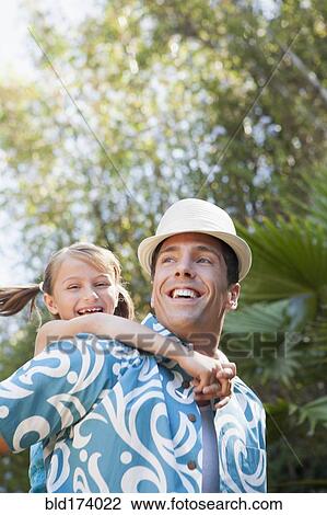 Low angle view of man carrying daughter outdoors View Large Photo Image Stock Image - Low angle view of man carrying daughter outdoors. Fotosearch