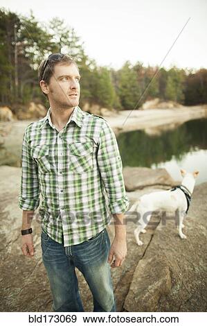 Man and dog standing near lake View Large Photo Image Stock Photo - Man and dog standing near lake. Fotosearch