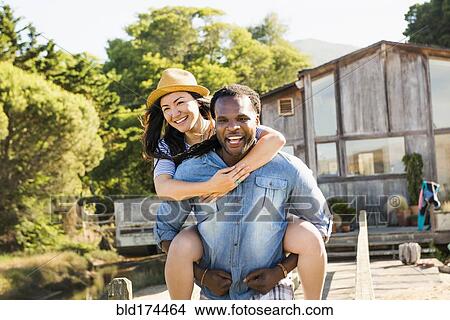 Man carrying girlfriend piggyback outdoors View Large Photo Image Picture - Man carrying girlfriend piggyback outdoors. Fotosearch