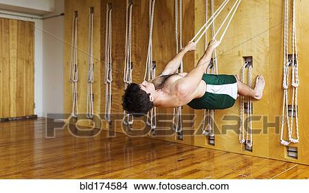 Picture - Man practicing acro yoga in studio. Fotosearch