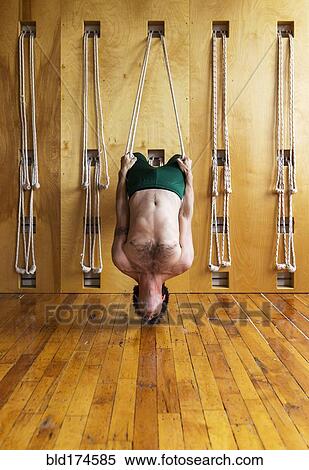 Man practicing acro yoga in studio View Large Photo Image Stock Photography - Man practicing acro yoga in studio. Fotosearch