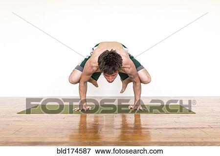 Stock Photo - Man practicing yoga in studio. Fotosearch