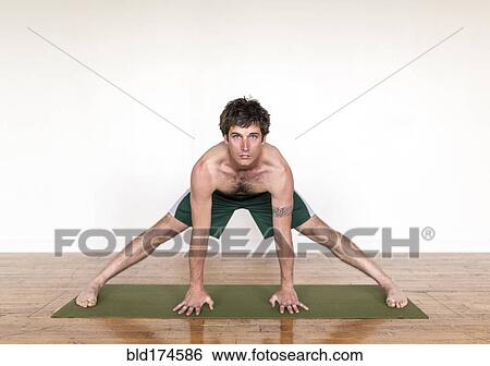 Stock Photograph - Man practicing yoga in studio. Fotosearch