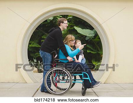 Man pushing paraplegic wife and son View Large Photo Image Stock Photo - Man pushing paraplegic wife and son. Fotosearch