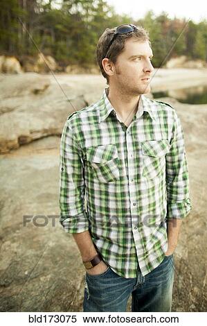 Stock Photography - Man standing on rocks. Fotosearch