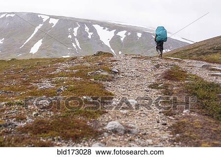 Mari backpacker walking on mountain path View Large Photo Image Stock Photo - Mari backpacker walking on mountain path. Fotosearch