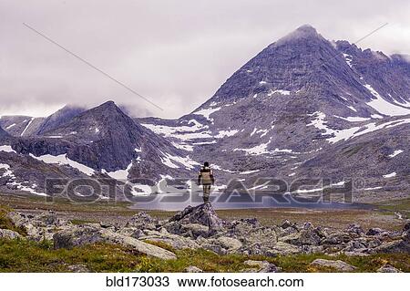 Stock Image - Mari hiker admiring remote mountains. Fotosearch