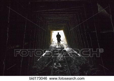 Stock Photograph - Mari man walking on tracks in mine. Fotosearch