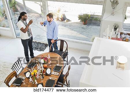 Stock Photo - Men drinking in dining room. Fotosearch