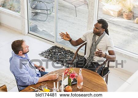 Men talking at dining room table View Large Photo Image Stock Image - Men talking at dining room table. Fotosearch