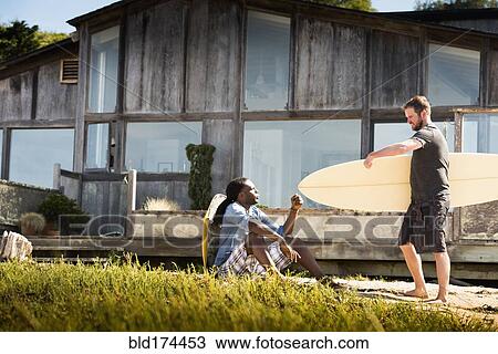 Stock Image - Men with surfboards outdoors. Fotosearch