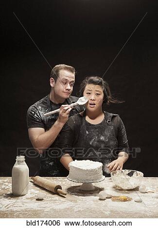 Messy couple baking cake View Large Photo Image Stock Photograph - Messy couple baking cake. Fotosearch