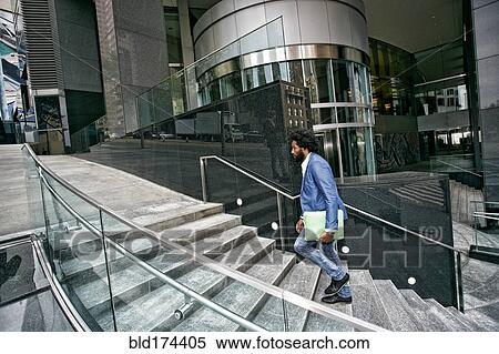 Mixed race businessman carrying digital tablet View Large Photo Image Stock Photography - Mixed race businessman carrying digital tablet. Fotosearch
