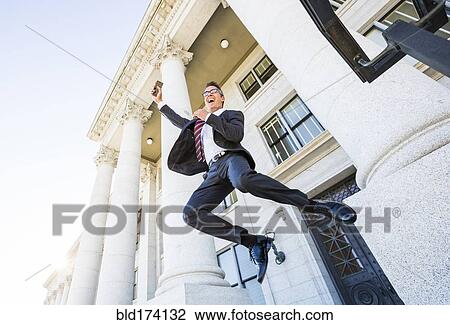Mixed race businessman jumping for joy outside courthouse View Large Photo Image Stock Image - Mixed race businessman jumping for joy outside courthouse. Fotosearch