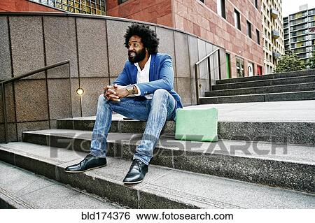 Stock Photograph - Mixed race businessman sitting on steps. Fotosearch